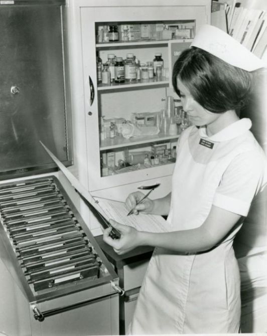 Nursing student reviewing charts, circa 1968