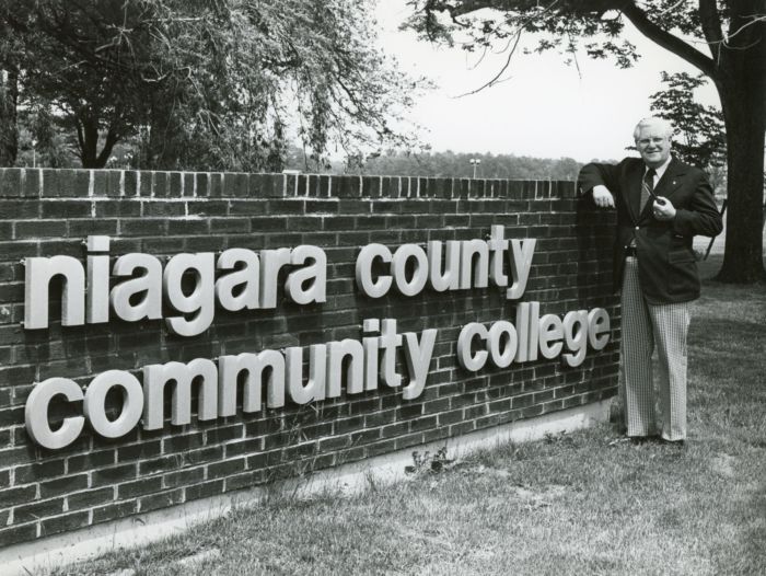 Ernest Notar with College sign